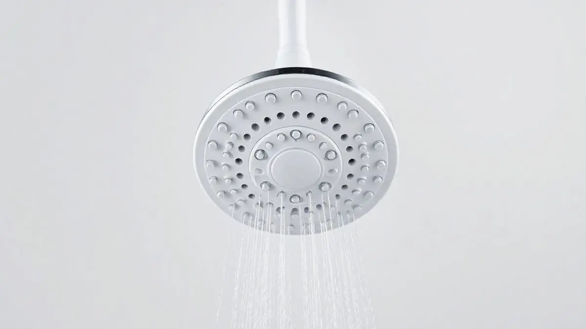 Ducha Pratik branca da Enerbras em fundo de estúdio, destacando o design moderno e minimalista do chuveiro elétrico para banheiro.
