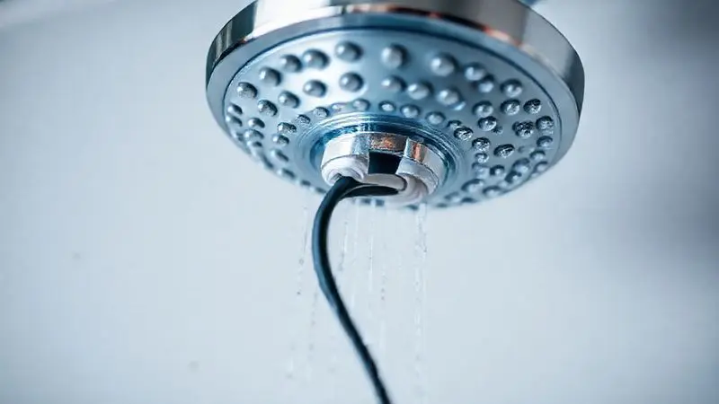 Detalhe da instalação elétrica segura de uma ducha, com fiação devidamente isolada e conectada, representando a importância da segurança do produto.